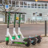 A row of three electric e-scooters of the company Lime