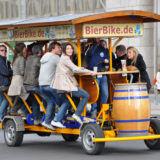 Young people pedal a beer bike